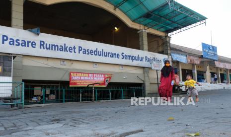 Warga berjalan di depan pasar Rejowinangun yang ditutup sementara di Ngadirejo, Temanggung, Jawa Tengah, Rabu  (17/6/2020). Gugus Tugas Percepatan Penanganan COVID-19 Kabupaten Temanggung menutup lima pasar tradisional yang menjadi episentrum penyebaran COVID-19 selama tiga hari untuk disterilisasi