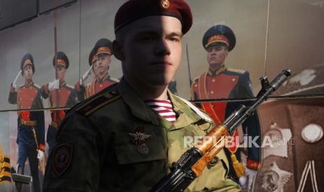 Seorang prajurit Rosguardia (Pengawal Nasional) Rusia berjalan melewati poster militer sebelum parade militer Hari Kemenangan di Lapangan Dvortsovaya (Istana) di St. Petersburg, Rusia, Senin, 9 Mei 2022. Pejabat Kanada dikecam karena menghadiri perayaan Hari Nasional Rusia di kedutaan. Ilustrasi.