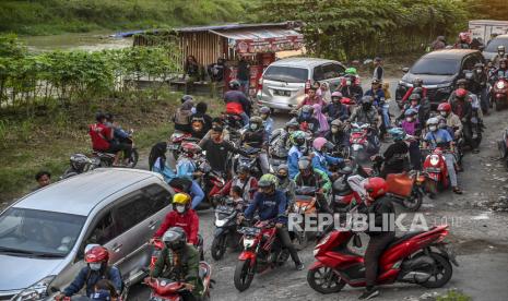 Pengendara sepeda motor melintas di jalur alternatif di Karawang, Jawa Barat, Jumat (29/4/2022). Petugas kepolisian telah menyiapakan jalur alternatif, termasuk pos pengamanan dan petunjuk arah untuk memandu para pemudik sepeda motor yang melintas guna mengurai kemacetan saat puncak arus mudik. 