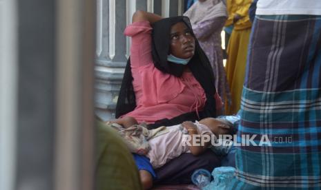 Seorang imigran etnis Rohingya bersama bayinya beristirahat di Meunasah atau Masjid setelah terdampar di kawasan pesisir Desa Kulee, Kecamatan Batee, Kabupaten Pidie, Aceh, Ahad (19/11/2023). Pemerintah setempat menyatakan sebanyak 241 orang imigran etnis Rohingya terdiri dari laki-laki dan perempuan dewasa serta anak-anak, termasuk diantaranya bayi yang  terdampar di daerah itu merupakan gelombang ketiga  dan saat ini ditampung sementara di Meunasah atau Masjid di kabupaten Pidie, Aceh. 