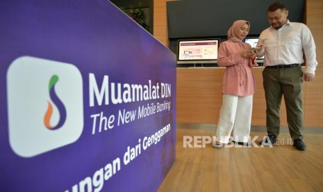 Nasabah PT Bank Muamalat Indonesia Tbk mengakses fitur Penerimaan Negara di aplikasi mobile banking Muamalat DIN di Jakarta, Kamis (21/3/2024). Bank Muamalat terus menambah fitur baru di aplikasi Muamalat DIN untuk memenuhi kebutuhan dan preferensi nasabah. Di antaranya adalah fitur Penerimaan Negara yang dapat digunakan oleh nasabah untuk melakukan pembayaran paspor. Kemudahan ini menjadikan nasabah Bank Muamalat yang antara lain ingin melaksanakan ibadah haji dan umrah ke Tanah Suci cukup membayar biaya pembuatan paspor via Muamalat DIN. 