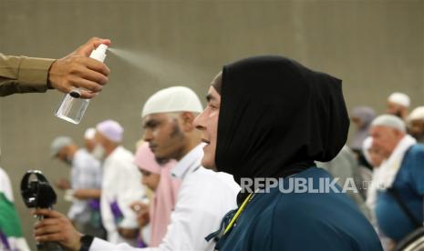 Petugas memercikan air kepada jamaah umrah untuk mengurangi sengatan matahari. (Ilustrasi)