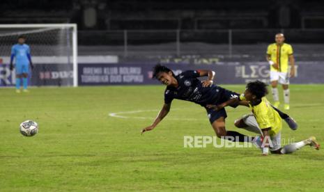 Pesepak bola Arema FC Jayus Hariono (kiri) berebut bola dengan pesepak bola Persik Kediri Yusuf (kanan) pada pertandingan Liga 1 di Stadion I Gusti Ngurah Rai, Denpasar, Bali, Ahad (27/2/2022) malam. 