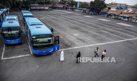 Warga berjalan menuju bus Damri yang terparkir di Terminal Cicaheum, Kota Bandung, Jumat (7/5). Selama masa larangan mudik Lebaran pada 6-17 Mei 2021, pelayanan perjalanan bus Antar Kota Antar Provinsi (AKAP) dan Antar Kota Dalam Provinsi (AKDP) di Terminal Cicaheum tidak beroperasi namun angkutan kota, Trans Metro Bandung dan Damri diizinkan beroperasi di wilayah aglomerasi Bandung Raya. Foto: Republika/Abdan Syakura