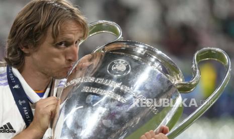  Luka Modric dari Real Madrid mencium trofi setelah memenangkan pertandingan sepak bola final Liga Champions antara Liverpool dan Real Madrid di Stade de France di Saint Denis dekat Paris, Ahad (29/5/2022) dini hari WIB. Modric pekan ini memastikan memperpanjang kontrak di Real Madrid.