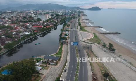 Foto aerial kendaraan melintas di objek wisata Pantai Padang, Sumatera Barat, Ahad (29/3/2020). Kondisi objek wisata dan jalan di kota itu lengang, menyusul penutupan objek wisata serta imbauan Pemkot Padang kepada warga untuk tidak berkerumun dan tetap berada di rumah mencegah penyebaran COVID-19 seiring bertambahnya pasien positif di Padang