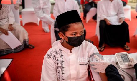 Santri mengecek kesehatan sebelum menerima vaksin Covid-19 Sinovac dosis pertama di Pondok Pesantren Ummul Qura, Tangerang Selatan, Banten, Ahad (1/8).  Sekitar 500 santri telah disuntik vaksin Covid-19 dosis pertama yang diselenggarakan Badan Intelejen Negara (BIN) bersama Kementerian Agama Tangerang Selatan guna mempercepat pemerataan vaksin bagi masyarakat dan kalangan pelajar. Republika/Thoudy Badai