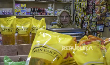 Pedagang menata minyak goreng kemasan rakyat MinyaKita yang dijual di kiosnya di Pasar Kosambi, Bandung, Jawa Barat, Kamis (7/12/2023).