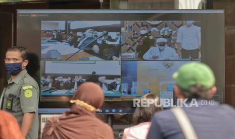 Layar yang menampilkan suasana sidang perdana atas kasus pelanggaran protokol kesehatan dengan terdakwa mantan Pemimpin Front Pembela Islam Rizieq Shihab yang digelar secara virtual di Pengadilan Negeri Jakarta Timur, Selasa (16/3). Ketua Majelis Hakim Pengadilan Negeri Jakarta Timur Suparman Nyompa memutuskan menunda sidang dakwaan akibat terkendala teknis, dan akan dilanjutkan pada Jumat 19 Maret 2021 mendatang. Republika/Thoudy Badai