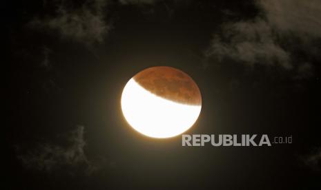  Bulan terlihat muncul dari gerhana bulan penuh, Ahad, 15 Mei 2022, dekat Moskow, Idaho. Warna jingga bulan disebabkan oleh bulan yang masuk ke dalam bayangan bumi.