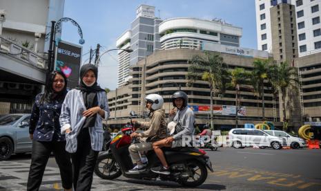 Pengguna kendaraan dan penyeberang jalan mengabaikan protokol kesehatan dengan tidak menggunakan masker di Jalan Braga, Bandung, Jawa Barat, Selasa (14/7/2020). Guna mendisiplinkan warga untuk menerapkan protokol pencegahan COVID-19, Pemerintah Provinsi Jawa Barat akan mengenakan denda Rp100 ribu hingga Rp150 ribu kepada warga yang kedapatan tidak menggunakan masker saat berada di tempat umum. 