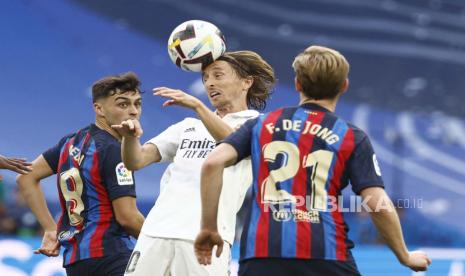 Luka Modric (tengah) dari Real Madrid melawan pemain FC Barcelona Pedri (kiri) dan Frenkie de Jong dalam laga el clasico.