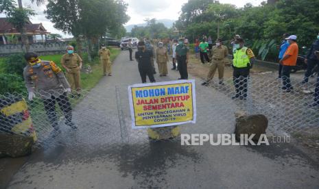 Bupati Trenggalek Moch Nur Arifin (tengah) dan Kapolres Trenggalek AKBP Jean Calvijn Simanjuntak (kiri) beserta jajaran memeriksa titik penutupan akses jalan sirip menuju Kabupaten Trenggalek, Jawa Timur, Senin (30/3/2020). Lebih dari 40 titik jalan sirip dan jalan desa yang berbatasan langsung dengan daerah lain sekitarnya (Kabupaten Tulungagung, Ponorogo, dan Pacitan) ditutup total dan hanya menyisakan tiga akses utama (Tulungagung-Trenggalek, Trenggalek-Ponorogo, dan Trenggalek-Pacitan) sebagai upaya pembatasan akses masuk warga dari luar daerah demi mencegah paparan wabah COVID-19 (Corona Virus Disease 2019) di wilayah tersebut