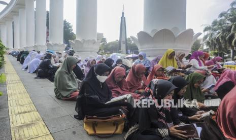 Sejumlah umat muslim membaca Alquran pada kegiatan Bogor Ngaos Al-Quran di Lawang Salapan, Kota Bogor, Jawa Barat, Ahad (24/4/2022). Kegiatan Bogor Ngaos Al-Quran yang diikuti sebanyak 1.000 peserta dari 63 komunitas itu bertujuan untuk mensyiarkan Al-Quran di bulan suci Ramadhan 1443 Hijriah. Tempat Hiburan Malam di Kota Bogor Wajib Tutup Selama Ramadhan