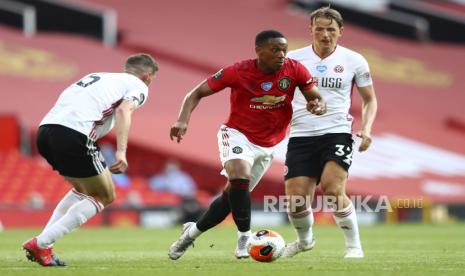 Striker Manchester United Anthony Martial, center, diadang dua pemain Sheffield United pada laga di Old Trafford, Manchester, Kamis (25/6) dini hari.