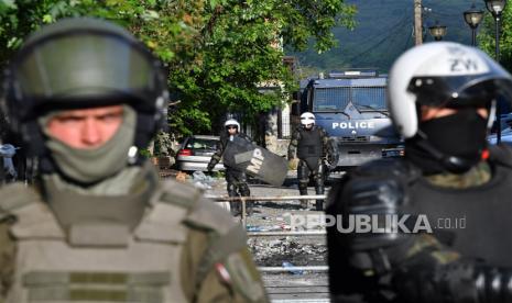  Prajurit pasukan penjaga perdamaian internasional yang dipimpin NATO (KFOR) mengatur posisi di depan gedung kotamadya di Zvecan, Kosovo, 30 Mei 2023. Setidaknya 25 penjaga perdamaian KFOR dan 53 warga sipil terluka setelah bentrokan antara pasukan keamanan dan etnis Serbia pecah di Zvecan pada 30 Mei 2023. Ketegangan berlanjut di wilayah utara Kosovo, dengan mayoritas etnis Serbia, yang muncul setelah walikota etnis Albania menjabat di empat kota setelah pemilu yang diboikot oleh komunitas Serbia.