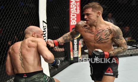  Dustin Poirier (kanan) meninju Conor McGregor dalam pertarungan UFC.