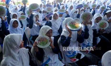 Sejumlah siswa menunjukkan kotak makan yang berisi menu bergizi seimbang pada kegiatan Gerakan Nasional Aksi Bergzi di SMP Negeri 19 Palembang, Sumsel, Rabu (26/10/2022). Aksi yang digelar kementerian kesehatan ini menyasar 1.028 sekolah se-Indonesia  dengan kegiatan pencegahan stunting melalui gerakan makanan bergizi dan pemberian tablet tambah darah bagi remaja putri. 