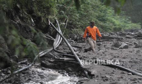 Penjaga peringatan dini erupsi Gunung Merapi Musdiantoro menunjukkan pipa air di aliran Sungai Boyong, Turgo, Pakem, Sleman, DI Yogyakarta, Jumat (8/1/2021). Luncuran material banjir lahar hujan dari puncak Gunung Merapi memutus saluran pipa sumber air bersih dari Turgo untuk warga Dusun Kaliurang, Ngandong dan Boyong. 