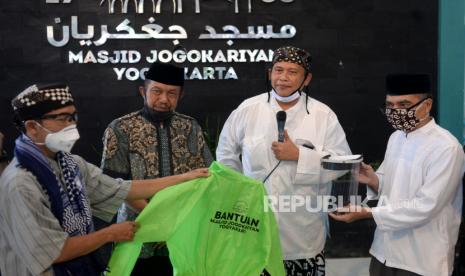 Ketua Dewan Syuro Takmir Masjid Jogokariyan, Ustaz Muhammad Jazir  (kedua kanan) bersama Walikota Jogja haryadi Suyuti (kedua kiri) saat penyerahan bantuan baju APD di Masjid Jogokariyan, Yogyakarta, Jumat (24/4). Sebanyak 300 baju APD dari Masjid Jogokariyan disalurkan kepada tenaga medis, TNI, Polisi, dan media