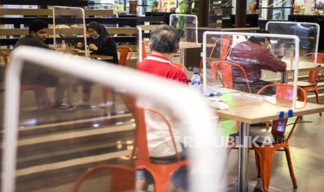 Pengunjung menikmati hidangan makanan di pusat jajanan serba ada (Food Court) di Bandung Electronic Center (BEC), Bandung, Jawa Barat, Kamis (9/7/2020). Sejumlah pengelola restoran dan pusat jajanan menerapkan protokol kesehatan ketat seperti pembatas di meja makan dan pengaturan jarak meja guna mencegah penyebaran COVID-19 di era tatanan normal baru. ANTARA FOTO/M Agung Rajasa/aww.