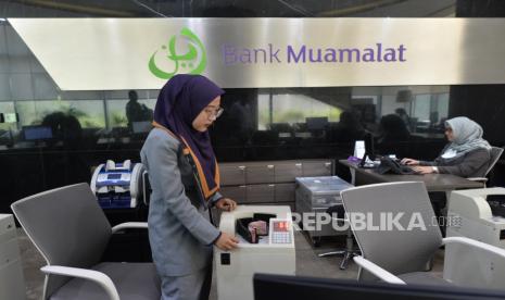 Karyawan melakukan aktivitas di banking hall kantor cabang Muamalat Tower, Jakarta.