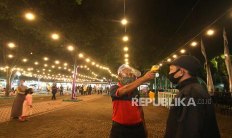 Petugas memeriksa suhu tubuh pengunjung pada simulasi pembukaan pusat kuliner di Banyuwangi, Jawa Timur, Rabu (10/6/2020). Simulasi pembukaan pusat kuliner dengan menerapkan protokol kesehatan tatanan normal baru itu, sebagai upaya membangkitkan kembali perekonomian pedagang yang sudah tiga bulan tutup akibat wabah COVID-19