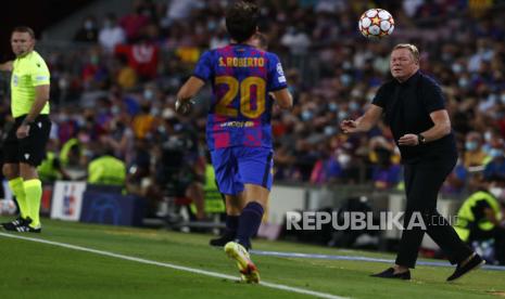  Pelatih kepala Barcelona Ronald Koeman mengembalikan bola ke pemain Barcelona Sergi Roberto pada pertandingan sepak bola grup E Liga Champions antara F.C. Barcelona dan Bayern di stadion Camp Nou di Barcelona, ??Spanyol, Rabu (15/9) dini hari WIB.