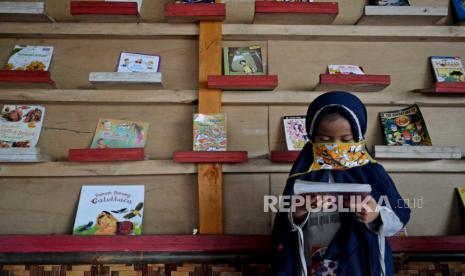 Sejumlah anak melihat buku di Saung Baca Komunitas Ngejah, Singajaya, Kabupaten Garut, Jawa Barat, Senin (8/2/2021). Saung baca di kawasan Garut Selatan tersebut dimanfaatkan sejumlah anak, pelajar, hingga mahasiswa untuk meningkatkan literasi membaca dan mengerjakan tugas sekolah di masa pembelajaran jarak jauh (PJJ). 