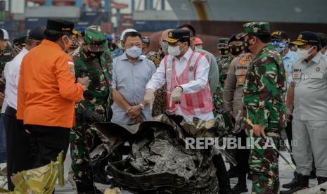 Panglima TNI Marsekal TNI Hadi Tjahjanto (kanan) bersama Menteri Perhubungan Budi Karya Sumadi (kedua kanan), Kepala BASARNAS Marsekal Madya TNI Bagus Puruhito (kiri) saat mengamati puing pesawat Sriwijaya Air PK-CLC dengan nomor penerbangan SJ-18 yang jatuh di perairan Pulau Seribu di Dermaga JICT, Jakarta, Selasa (12/1).