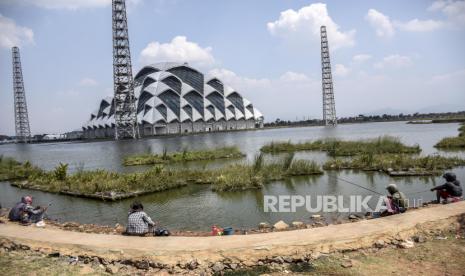 Warga memancing di embung proyek pembangunan Masjid Al Jabbar di Gedebage, Kota Bandung, Rabu (29/9). Pemerintah Provinsi Jawa Barat kembali melanjutkan proyek pembangunan Masjid Al Jabbar setelah dihentikan selama 1,5 tahun akibat pandemi Covid-19 dan ditargetkan akan rampung serta diresmikan pada akhir tahun 2022. Foto: Republika/Abdan Syakura