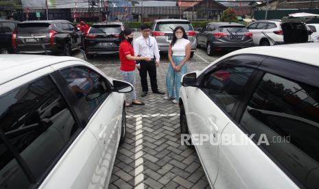 Tenaga penjual memberikan informasi kepada calon pembeli saat melihat kondisi mobil bekas yang ada di ruang pamer penjualan mobil bekas di Kebayoran Lama, Jakarta Selatan, Selasa (30/8/2022). 