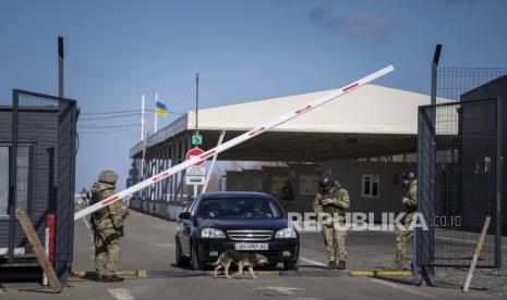 Sebuah mobil menunggu untuk melintasi pos pemeriksaan dari wilayah yang dikuasai oleh separatis yang didukung Rusia ke wilayah yang dikendalikan oleh pasukan Ukraina di Novotroitske, Ukraina timur, Senin, 21 Februari 2022. 