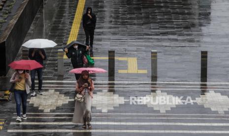 Warga memakai payung saat hujan turun di Jalan Jenderal Sudirman, Jakarta Selatan, Jumat (19/1/2024). Hujan melanda sejumlah wilayah di Jabodetabek sejak dini hari hingga jam berangkat kerja dan sekolah. BMKG memprediksikan puncak musim hujan diperkirakan akan berlangsung pada minggu pertama Februari di sejumlah wilayah di Indonesia.