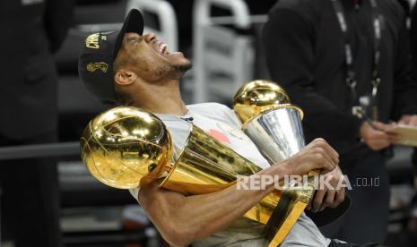 Reaksi forward Milwaukee Bucks Giannis Antetokounmpo saat memegang trofi NBA Championship, kiri, dan trofi Most Valuable Player (MVP)setelah mengalahkan Phoenix Suns di Game 6 Final bola basket NBA di Milwaukee, Amerika Serikat, Selasa, 20 Juli 2021. Bucks menang 105-98.