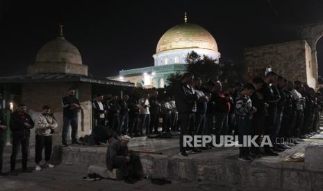 Jamaah Palestina melakukan shalat tarawih,pada bulan suci Ramadhan, di sebelah Dome of Rock di kompleks Masjid Al-Aqsa di Kota Tua Yerusalem, Sabtu (8/4/2023). Menteri Pertahanan Israel pada hari Sabtu memperpanjang penutupan larangan masuk ke Israel bagi warga Palestina dari Tepi Barat dan Jalur Gaza yang diduduki selama liburan Paskah Yahudi, sementara polisi meningkatkan pasukan di Yerusalem pada malam perayaan keagamaan yang sensitif.