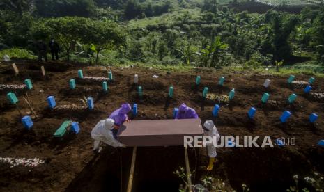 Petugas memakamkan jenazah di pemakaman khusus COVID-19 di Cipageran, Cimahi, Jawa Barat, Rabu (30/6/2021). Menurut Dinas Perumahan dan Kawasan Pemukiman (DPKP) Kota Cimahi ketersediaan lahan pemakaman COVID-19 terus berkurang akibat terus meningkatnya angka kematian akibat COVID-19 sementara Kota Cimahi masih terdata sebagai salah satu zona merah dari 11 daerah zona merah COVID-19 di Jawa Barat. 