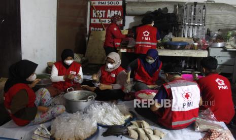 Petugas PMI Solo dibantu relawan menyiapkan menu makan di dapur umum kantor PMI Solo, Jawa Tengah, Ahad (6/3/2022). Dapur umum tersebut untuk membantu kebutuhan makan harian bagi 108 warga binaan Griya Peduli PMI dan Griya Bahagia PMI di Mojosongo, Solo yang sedang menjalani isolasi mandiri karena positif COVID-19. 