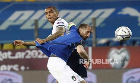 Bek timnas Italia Giorgio Chiellini (Kanan) dan Josh Magennis (Kiri) dari Irlandia Utara beraksi selama pertandingan sepak bola kualifikasi Piala Dunia FIFA Qatar 2022 antara Italia dan Irlandia Utara di Stadion Ennio Tardini di Parma, Italia, 25 Maret 2021.