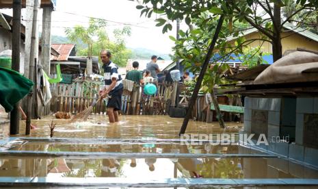 Seorang warga berada di depan rumah yang terendam banjir di Kota Gorontalo, Gorontalo, Kamis (20/6/2024). Dua kecamatan yaitu Kota Timur dan Dumbo Raya terendam banjir hingga 100 cm akibat hujan deras yang menyebabkan meluapnya air sungai Bone. 