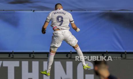 Karim Benzema dari Real Madrid merayakan setelah mencetak gol pembuka dalam pertandingan sepak bola La Liga Spanyol antara Real Madrid dan Valencia di stadion Alfredo Di Stefano di Madrid, Spanyol,  Ahad (14/2).