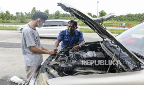 Seorang teknisi memperbaiki mobil milik pemudik yang mengalami kerusakan di pinggir ruas Jalan Tol Cikopo-Palimanan, Subang, Jawa Barat, Kamis (28/4/2022). 