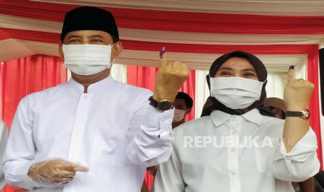 Calon Wali Kota Tangerang Selatan nomor urut satu Muhammad (kiri) beserta istri menunjukan jarinya yang diberi tinta usai mencoblos di TPS 29 Ciputat, Tangerang Selatan, Banten, Rabu (9/12/2020). Sebanyak 976.019 orang terdaftar dalam Daftar Pemilih Tetap (DPT) pada Pilkada Kota Tangerang Selatan 2020 yang diikuti tiga pasang calon Wali Kota dan Wakil Wali Kota Tangerang Selatan yakni nomor urut satu Muhammad - Rahayu Saraswati, nomor urut dua Azizah - Ruhamaben dan nomor urut tiga Benyamin Davnie - Pilar Saga Ikhsan.