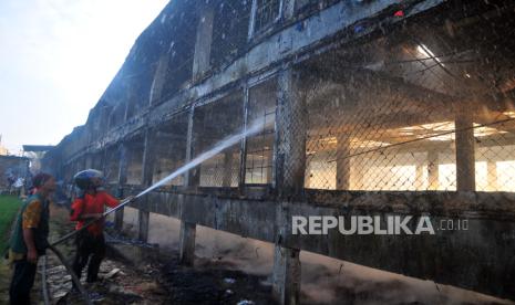 Petugas pemadam kebakaran berusaha memadamkan sisa api yang membakar bangunan peternakan ayam di Desa Hadipolo, Kudus, Jawa Tengah, Rabu (11/9/2024). Sebanyak enam mobil damkar dikerahkan untuk memadamkan kebakaran yang diduga akibat hubungan arus pendek yang menyebabkan sekitar 36.000 ekor ayam mati serta kerugian mencapai miliaran rupiah tersebut. 