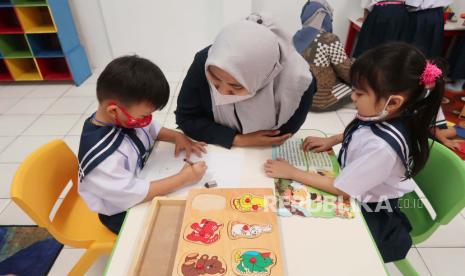 Seorang guru mendampingi siswa siswinya saat belajar dan mengimplementasikan Kurikulum Merdeka di dalam kelas pada hari pertama masuk sekolah. Kurikulum Merdeka memang memberikan konsep yang ideal, tapi justru bisa jadi utopia.