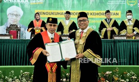 Rektor Unissula, Prof Gunarto (kanan), berfoto bersama pengasuh pesantren Al Pesantren Al Bahjah, Prof Yahya Zaenul Muarif (Buya Yahya), dalam acara pengukuhan Guru Besar Kehormatan bidang Hukum Islam di kampus Universitas Islam Sultan Agung (Unissula) Semarang, Kamis (19/1).