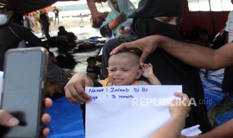 Petugas Imigrasi Kelas 1 Medan melakukan pendataan bagi pengungsi etnis Rohingnya di Desa Karang Gading, Kecamatan Labuhan Deli, Kabupaten Deli Serdang, Sumatera Utara, Selasa (2/1/2024). Imigrasi Kelas 1 Medan mendata sebanyak 157 pengungsi etnis Rohingnya yang terdiri dari 48 anak-anak dan 106 orang dewasa yang terdampar di perairan Desa Karang Gading pada Sabtu (30/12/). 