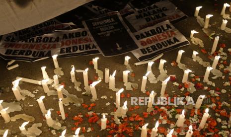 Suporter meletakkan lilin dan tulisan dalam aksi keprihatinan Tragedi Stadion Kanjuruhan di depan Stadion Gelora Bung Karno (GBK), Jakarta, Ahad (2/10/2022). Aksi gabungan dari sejumlah kelompok suporter lintas klub sepak bola tersebut menuntut pemerintah dan aparat hukum mengusut tuntas secara adil dan menghukum semua yang bertanggung jawab atas kasus kerusuhan usai pertandingan Arema lawan Persebaya pada Sabtu (1/10/2022) malam di Stadion Kanjuruhan, Malang, Jawa Timur.  Doa untuk para korban tragedi Stadion Kanjuruhan juga dipanjatkan ribuan pendukung PSIS Semarang dari Snex dan Panser Biru di Stadion Jatidiri, Semarang, Jawa Tengah, Ahad (2/10/2022) malam.  