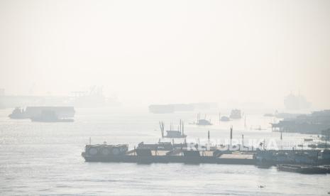 Kapal tongkang pengangkut batu bara melintasi Sungai Musi yang tertutup kabut asap di Palembang, Sumatera Selatan, Jumat (1/9/2023). Berdasarkan pantauan satelit Himawari SM 9 terdeteksi sebaran asap di wilayah Sumatera Selatan, Kalimantan Barat, Kalimantan Tengah dan Kalimantan Selatan yang merupakan dampak dari kebakaran hutan dan lahan (Karhutla) yang terjadi di daerah tersebut. 