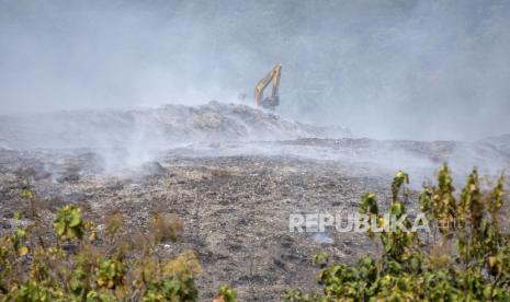 Petugas menggunakan alat berat menguruk tanah untuk memadamkan api di TPA Sarimukti, Cipatat. DLH Jabar sebut tidak ada jaminan TAP Sarimukti bisa bekerja normal kembali.